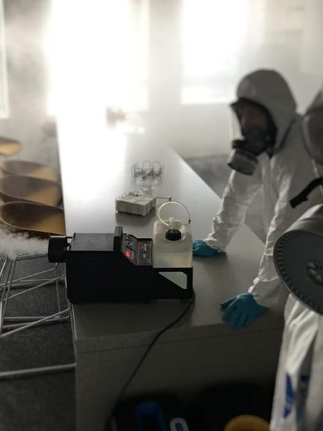 Techniker bei Desinfektionsarbeiten in Schutzkleidung